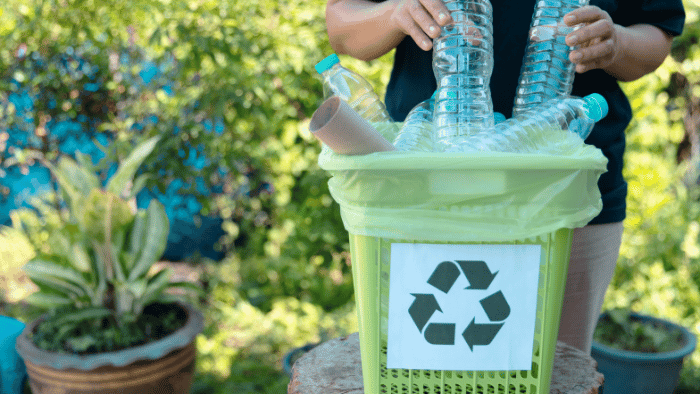 man putting bottles in recycling bin