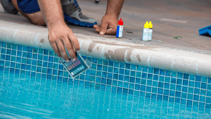 Man testing the swimming pool water