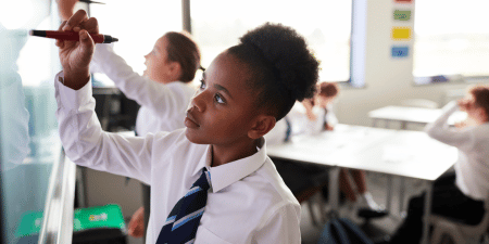 School pupil writing on board