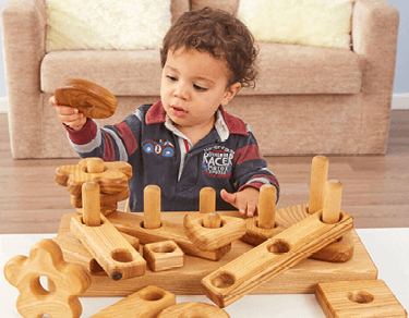 Toddler playing with wooden toys