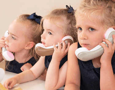 Toddlers using wooden phones