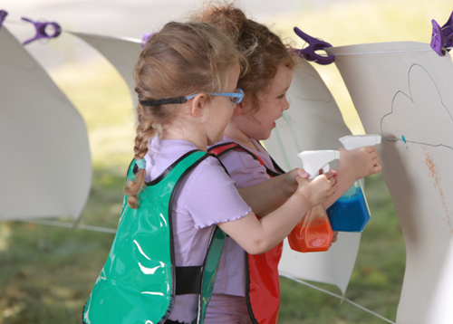 Two girls doing arts and crafts outdoors