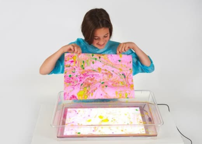 child holding up art work
