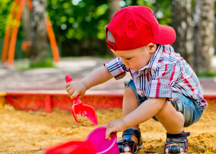 child digging in sand pit