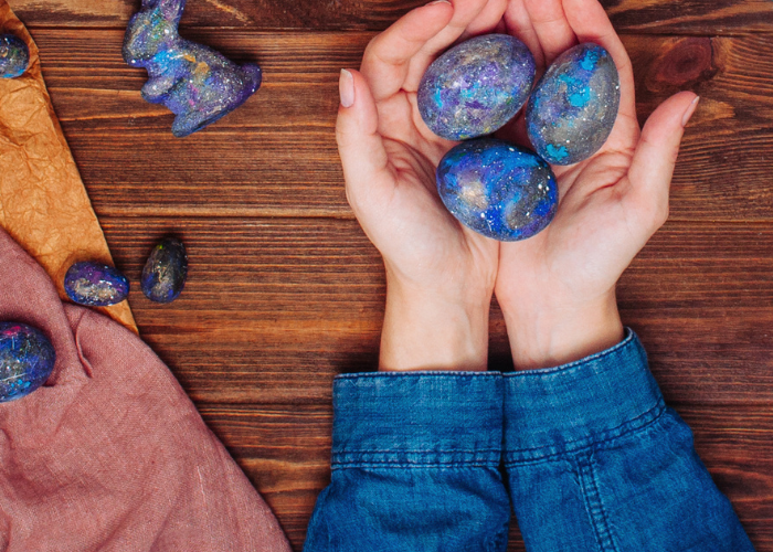 Hands holding out marbled eggs