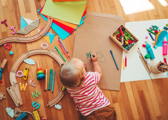 children drawing whilst lying on the floor 