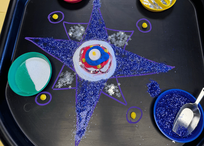 Rangoli design with glitter and diya lamp