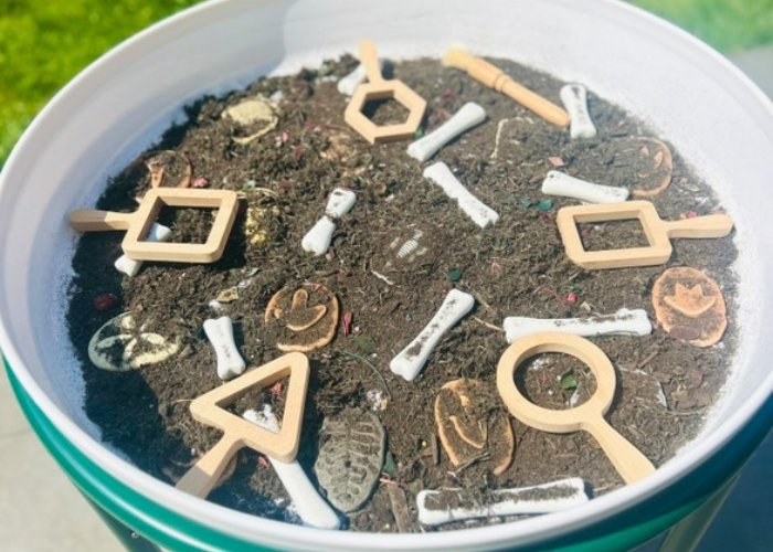Outdoor learning set up fossil dig activity by tufftray_adventures (Instagram)