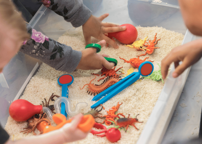 children playing with bugs in play tray