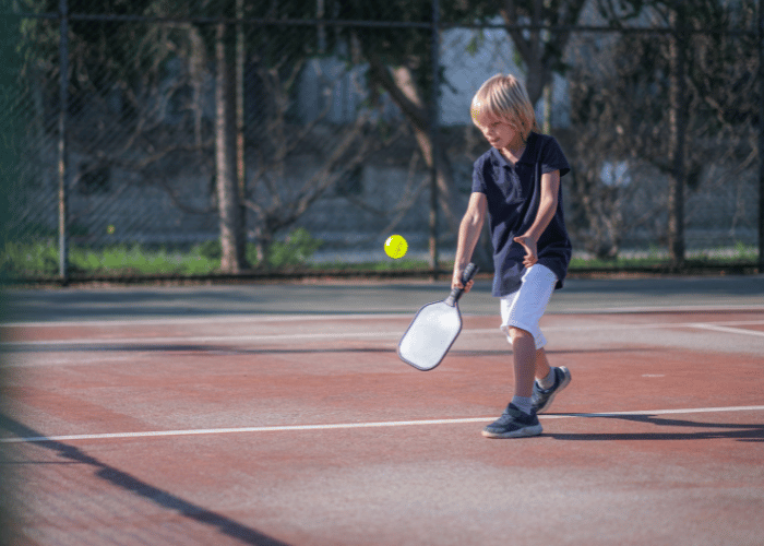 Boy hitting a pickleball