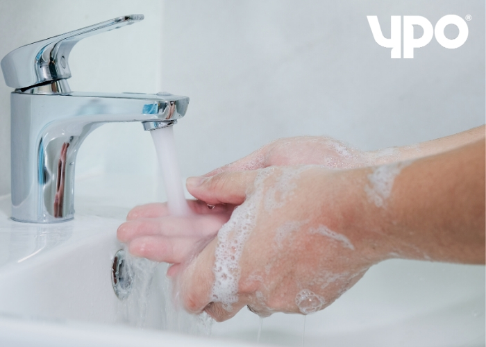 man washing hands in sink