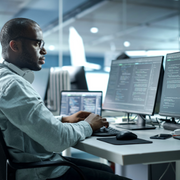 Man sat at desk looking at computers 
