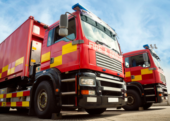 Two red fire truck emergency vehicles