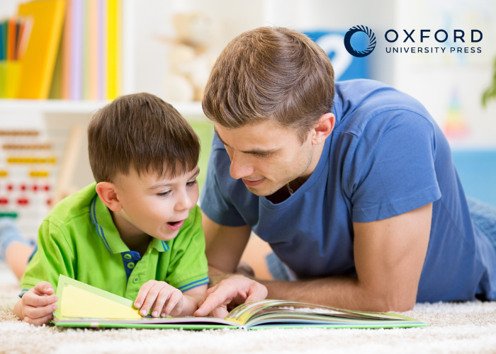 Young boy reading a book with his father