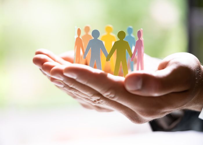 Hands holding craft silhouettes of people