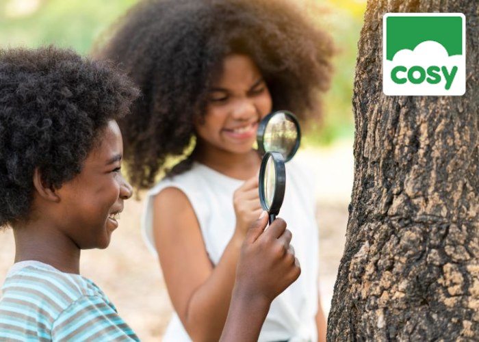 Two children smiling whilst learning outdoors