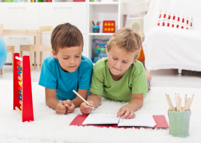 children lying on the floor writing in a floor book