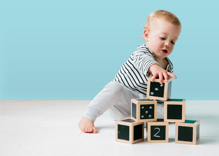 Child playing with montessori toys- Fun with Chalk - Wooden Cubes