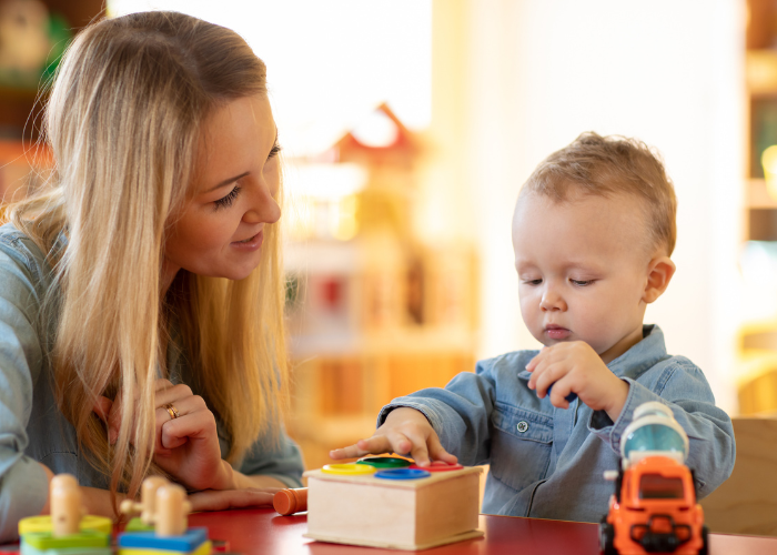 Teacher helping child with sensory activity